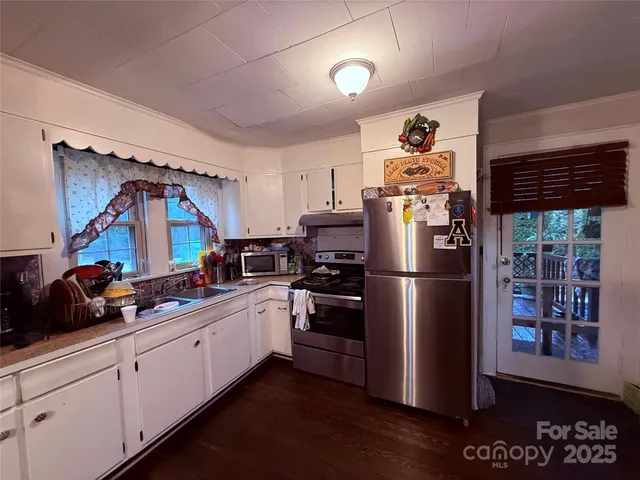 a kitchen with stainless steel appliances granite countertop a refrigerator and a sink