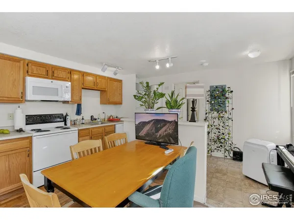 a kitchen with stainless steel appliances kitchen island granite countertop a stove a sink a microwave a dining table and chairs