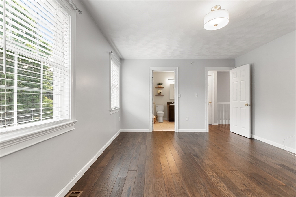 2 Ricciuti Drive, Unit 9 Quincy, MA 02169 - Photo 23 of 40 a view of an empty room with wooden floor and a window