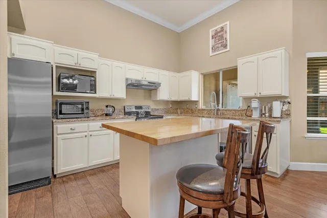 a kitchen with granite countertop a sink stainless steel appliances and cabinets