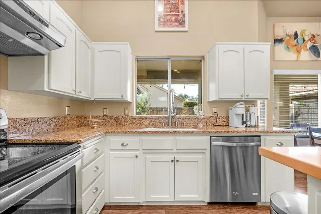 a living room with furniture a large window and wooden floor
