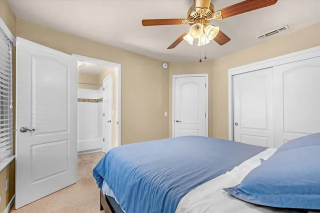 a bed sitting in a bedroom next to a window and chandelier