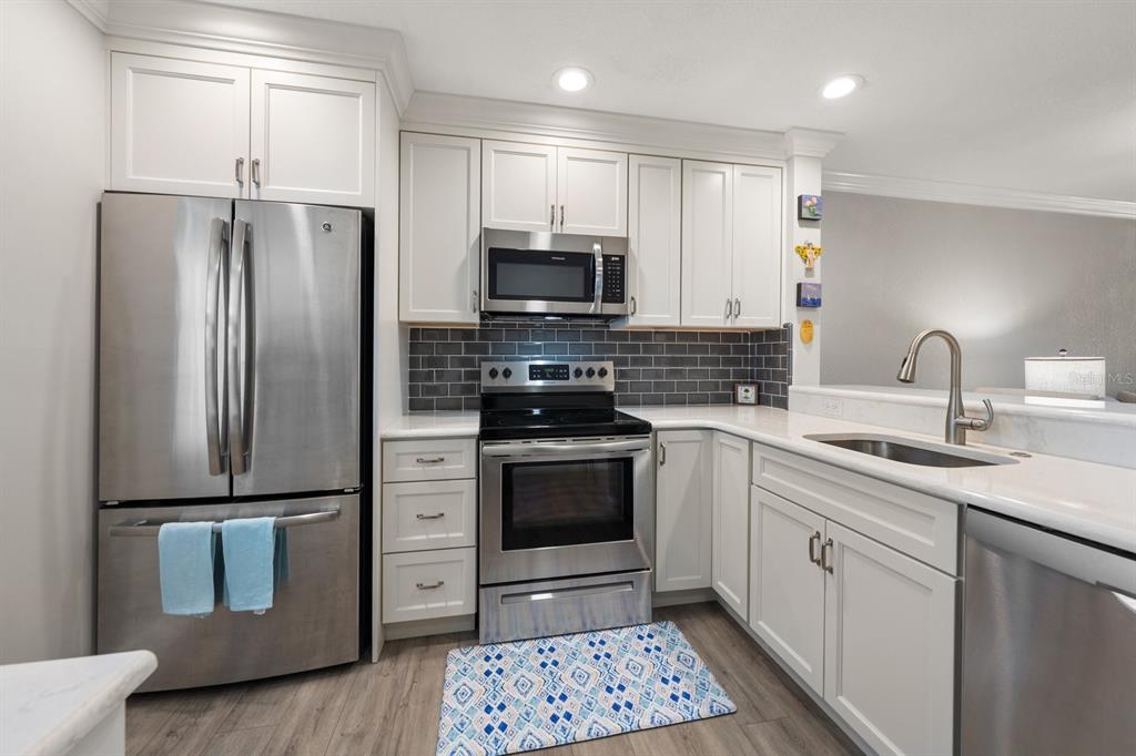 1701 Pinehurst Road, Unit 17G Dunedin, FL 34698 - Photo 2 of 30 a kitchen with granite countertop a refrigerator stove and sink