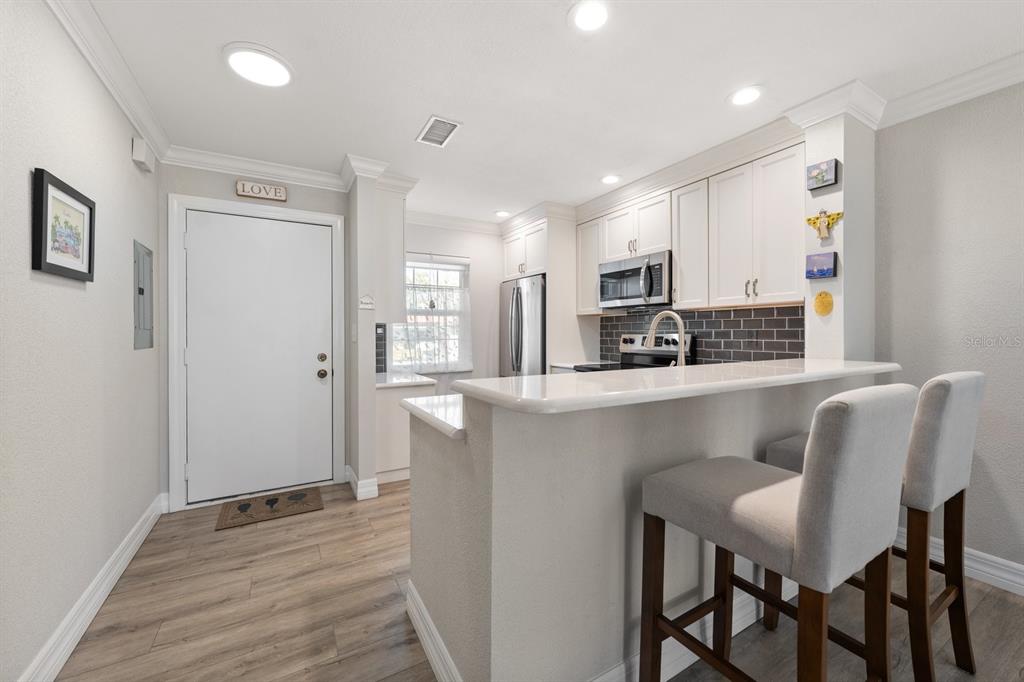 1701 Pinehurst Road, Unit 17G Dunedin, FL 34698 - Photo 5 of 30 a kitchen with kitchen island white cabinets and stainless steel appliances