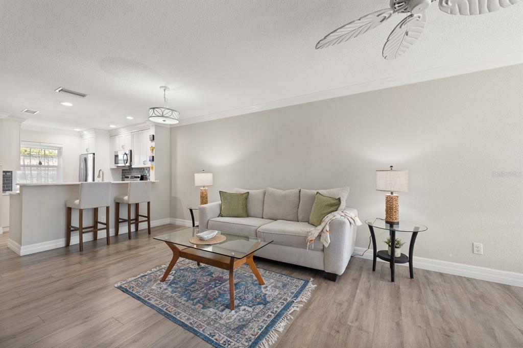 1701 Pinehurst Road, Unit 17G Dunedin, FL 34698 - Photo 6 of 30 a living room with furniture and a dining table with wooden floor