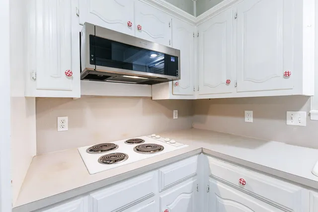 a kitchen with cabinets appliances a sink and a window