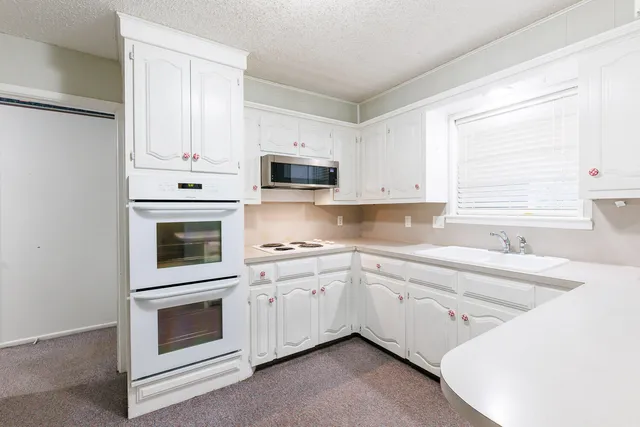 a kitchen with cabinets appliances and a counter space