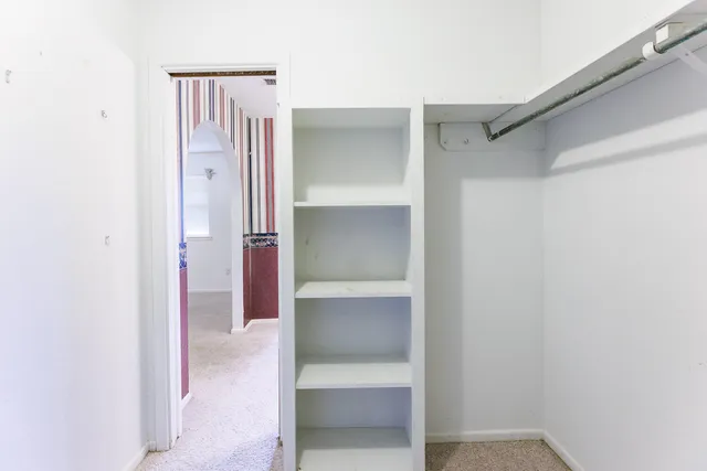 an empty room with a window and a ceiling fan