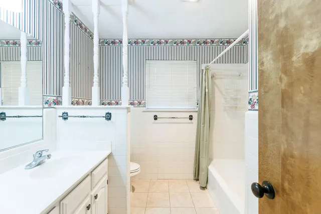 an empty room with a window and a chandelier fan