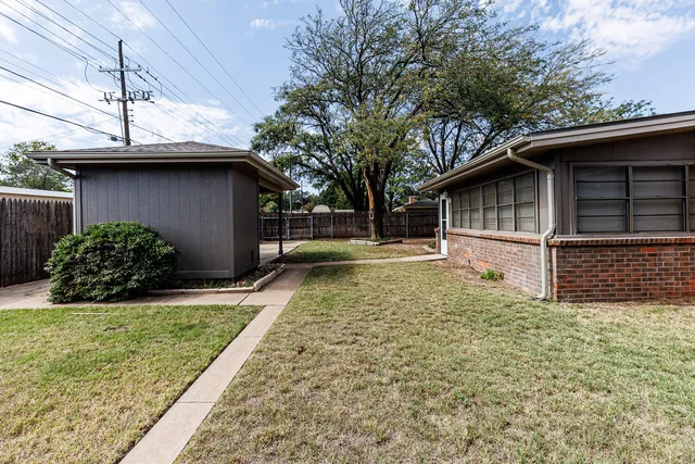 a view of backyard with a large tree