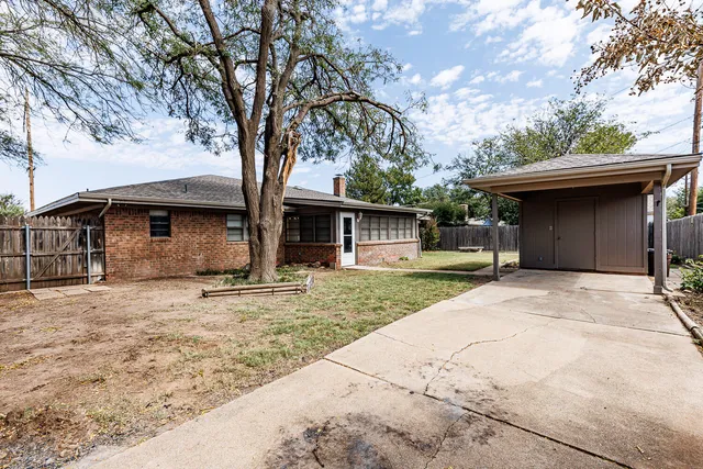 a backyard of a house with glass top table and chairs