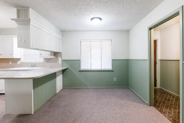 a kitchen with white cabinets and white appliances