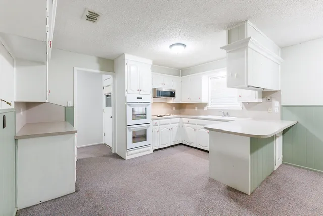 a kitchen with granite countertop white cabinets and a sink