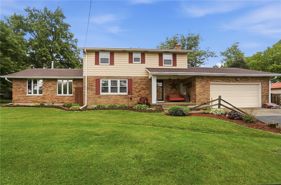 A classic brick and siding home with a welcoming front porch and attached garage.