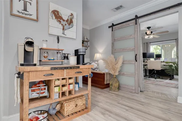 a kitchen with stainless steel appliances kitchen island granite countertop a refrigerator oven a sink dishwasher and white cabinets with wooden floor