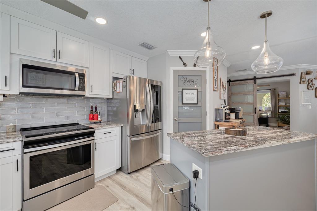1868 Overview Drive New Port Richey, FL 34655 - Photo 15 of 69 a kitchen with stainless steel appliances kitchen island granite countertop a refrigerator oven a stove a sink and a center island