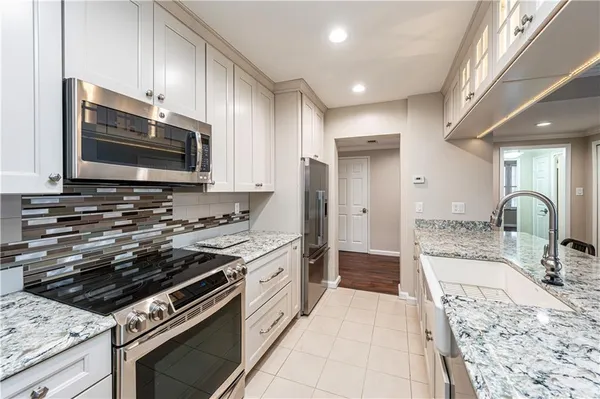 a kitchen with stainless steel appliances granite countertop a stove and a microwave