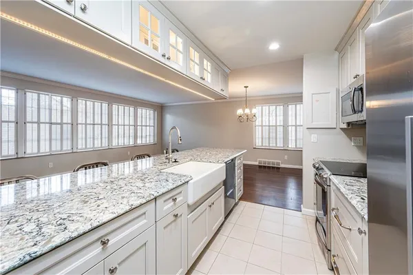 a large white kitchen with granite countertop a lot of counter space