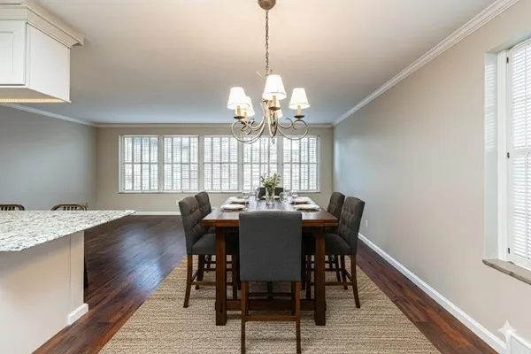 a view of a dining room with furniture a chandelier and wooden floor