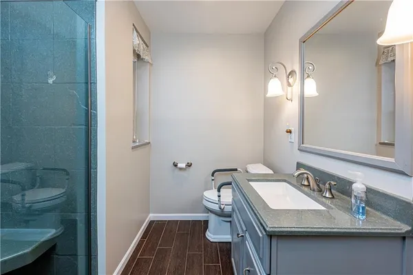 a bathroom with a sink a toilet and shower