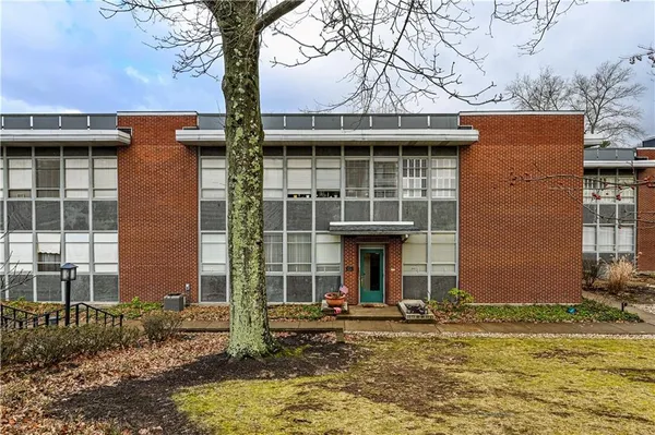 a view of a house with large windows and a small yard