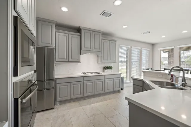 a kitchen with stainless steel appliances granite countertop a refrigerator sink and stove