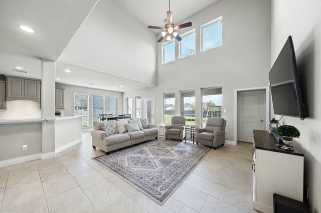 a living room with furniture a large window and a chandelier