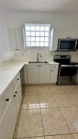 a kitchen with a stove a sink and a refrigerator
