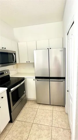 a kitchen with a refrigerator and a stove top oven