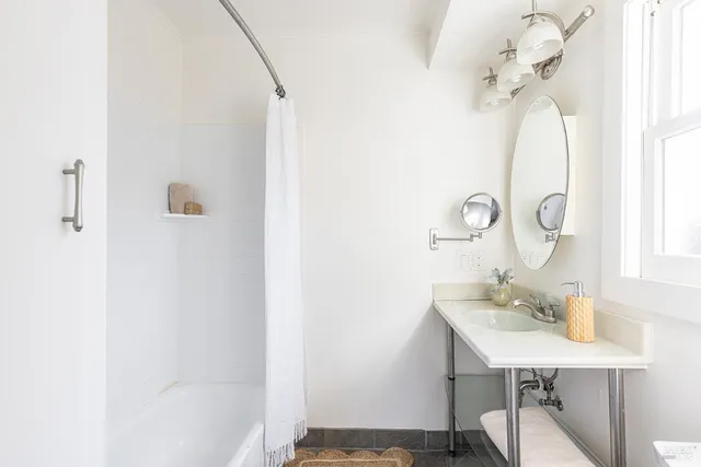 a bathroom with a sink a mirror and a shower