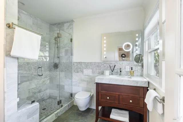 a bathroom with a sink toilet a mirror and shower