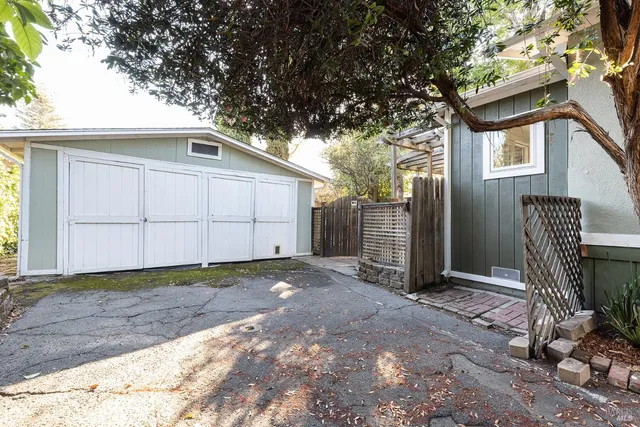 a view of backyard with a table and chairs and wooden fence