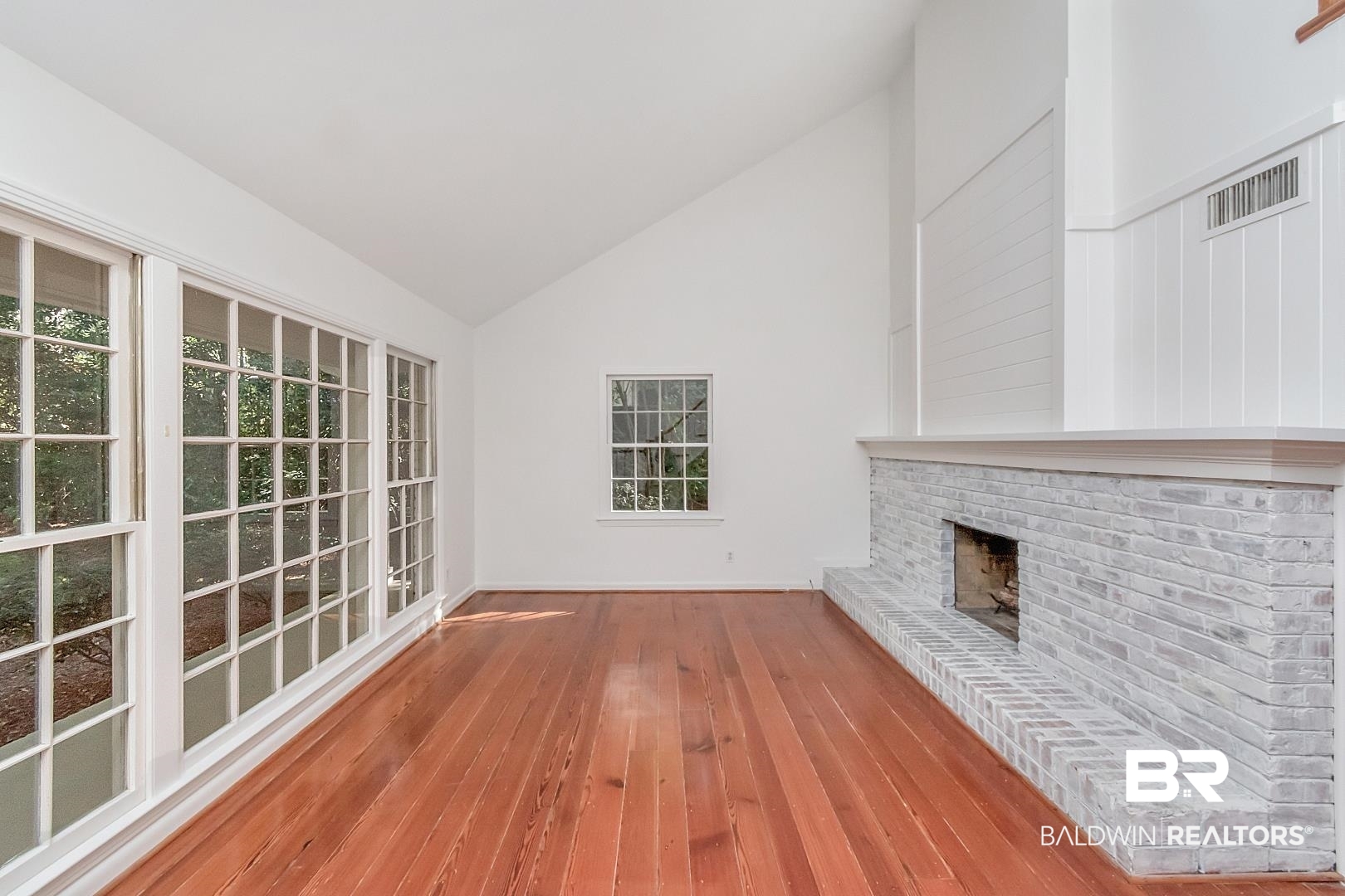 117 Ridgelawn Drive West Mobile, AL 36608 - Photo 2 of 31 living room featuring wide plank pine wood flooring, Dual sided woodburning brick fireplace, high vaulted ceiling.