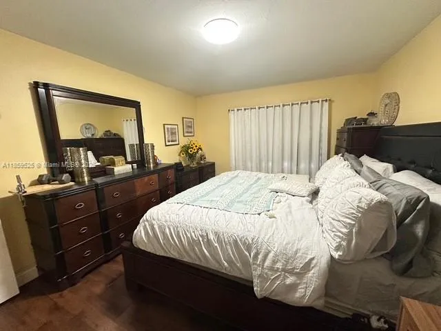 a bedroom with a bed and a flat tv screen on dresser