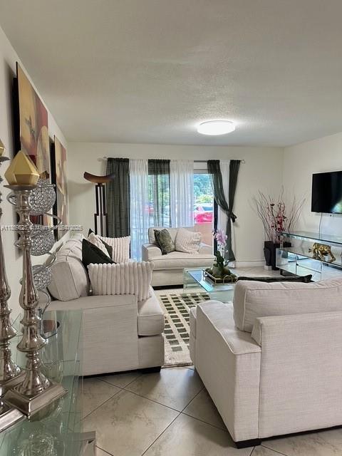 17901 Northwest 68th Avenue, Unit R101 Hialeah, FL 33015 - Photo 2 of 20 a living room with furniture and a flat screen tv