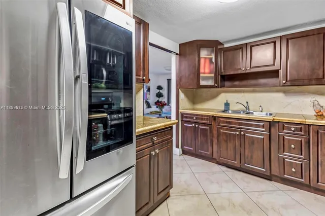 a kitchen with stainless steel appliances granite countertop a refrigerator and wooden cabinets