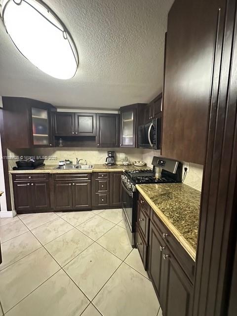 17901 Northwest 68th Avenue, Unit R101 Hialeah, FL 33015 - Photo 7 of 20 a kitchen with stainless steel appliances granite countertop a stove a sink and a microwave