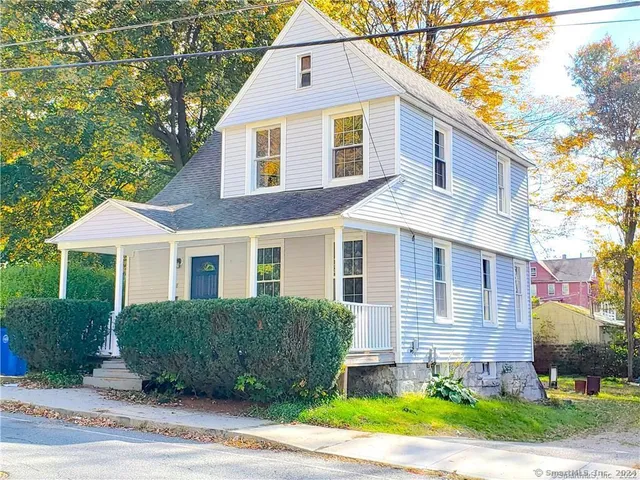 a front view of a house with a yard and potted plants