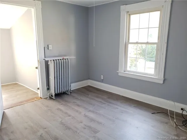 an empty room with a window and wooden floor