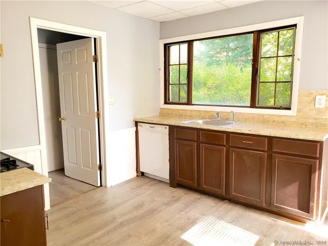 a view of a kitchen with a sink and dishwasher refrigerator with wooden floor