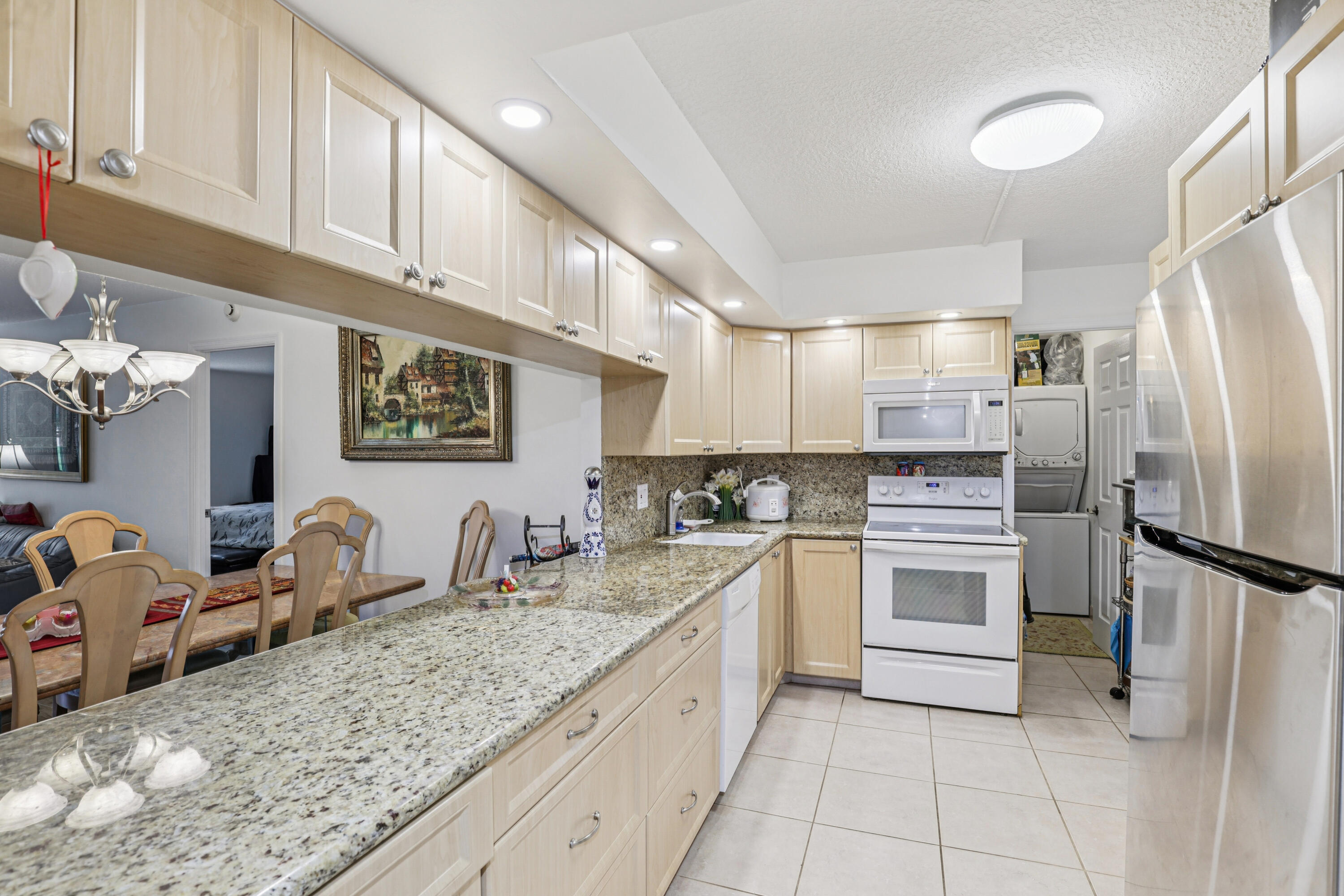 250 Northwest 67th Street, Unit 119 Boca Raton, FL 33487 - Photo 2 of 35 a kitchen with granite countertop a sink stainless steel appliances and cabinets