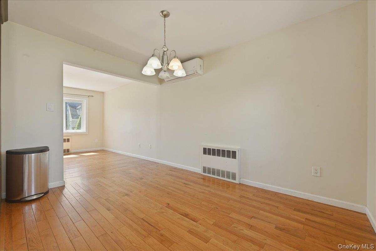 1719 William Street Merrick, NY 11566 - Photo 15 of 38 a view of a room with wooden floor and chandelier