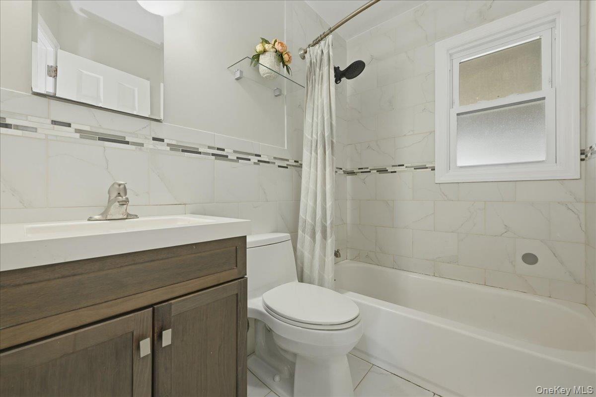 1719 William Street Merrick, NY 11566 - Photo 17 of 38 a bathroom with a sink a toilet and shower