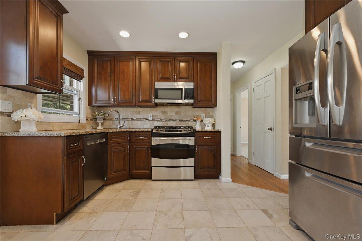 1719 William Street Merrick, NY 11566 - Photo 3 of 38 a kitchen with stainless steel appliances granite countertop a refrigerator stove a sink and dishwasher