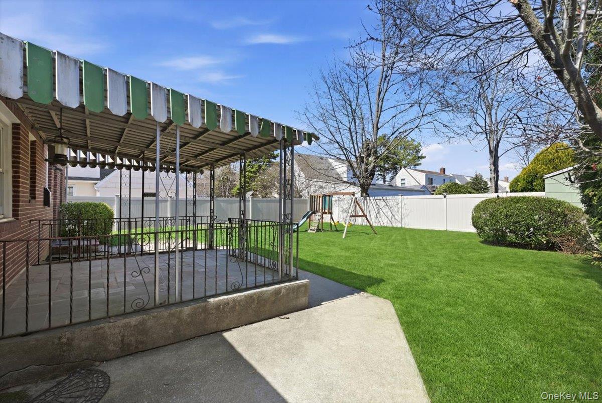 1719 William Street Merrick, NY 11566 - Photo 34 of 38 a view of a backyard with a small cabin and a chair