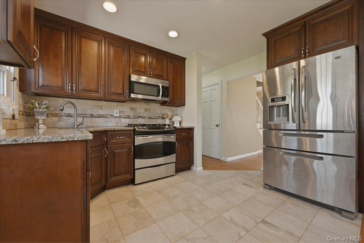 1719 William Street Merrick, NY 11566 - Photo 4 of 38 a kitchen with stainless steel appliances granite countertop a refrigerator stove top oven and sink