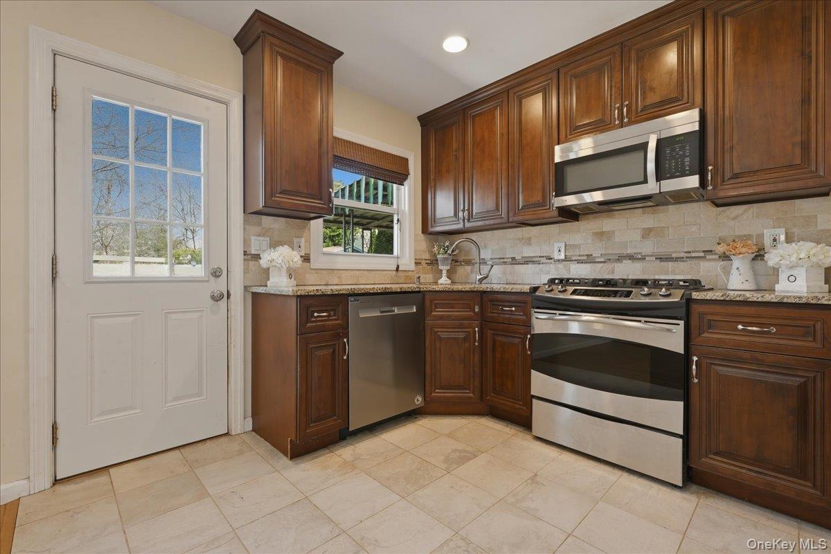 1719 William Street Merrick, NY 11566 - Photo 5 of 38 a kitchen with stainless steel appliances granite countertop a stove a sink and a microwave