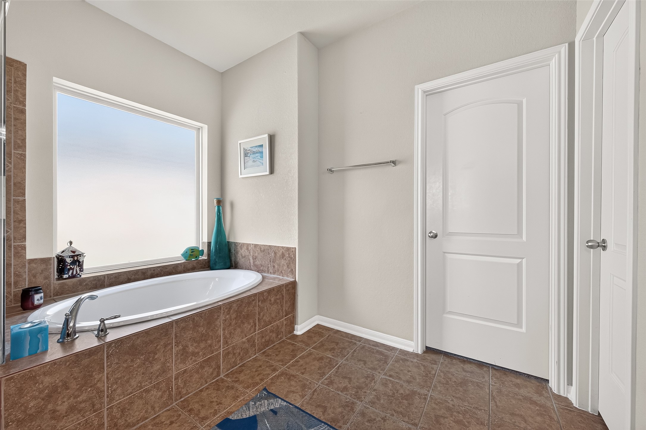 4910 Culver Lane Rosenberg, TX 77471 - Photo 36 of 50 This bathroom features a spacious tub set in a tiled surround, large frosted privacy window for natural light, and a clean, modern design with neutral colors.