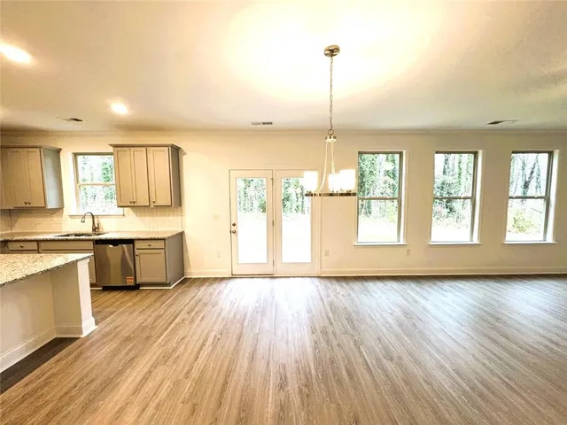 a view of a kitchen with a sink wooden floor and a large window