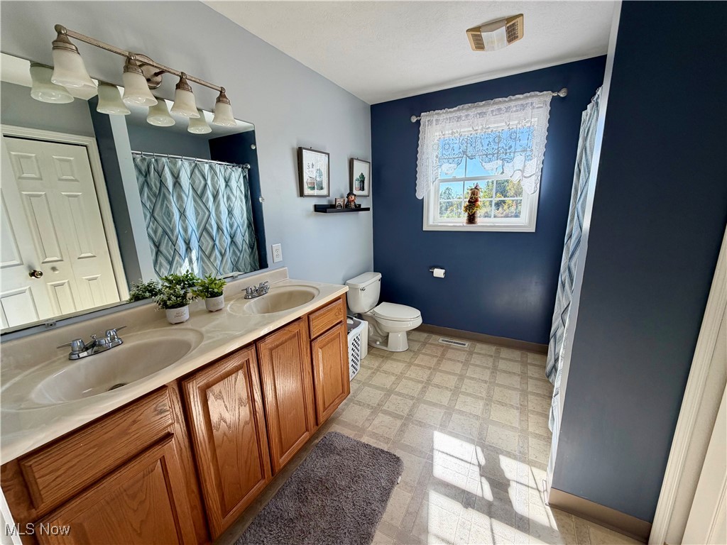 7374 Virginia Road Atwater, OH 44201 - Photo 30 of 49 Bathroom featuring double vanity, light floors, and curtained shower